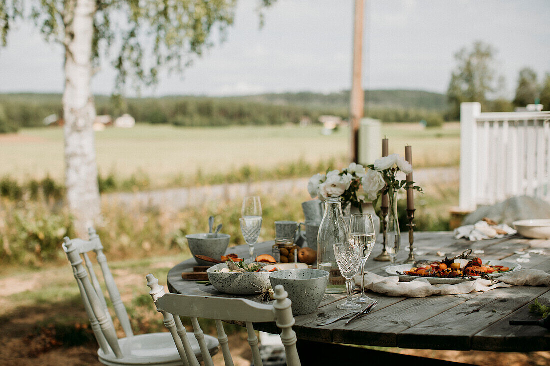 Gedeckter Holztisch im Garten