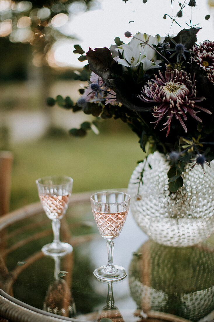 Rosé-Champagner in Kristallgläsern auf Tisch im Garten