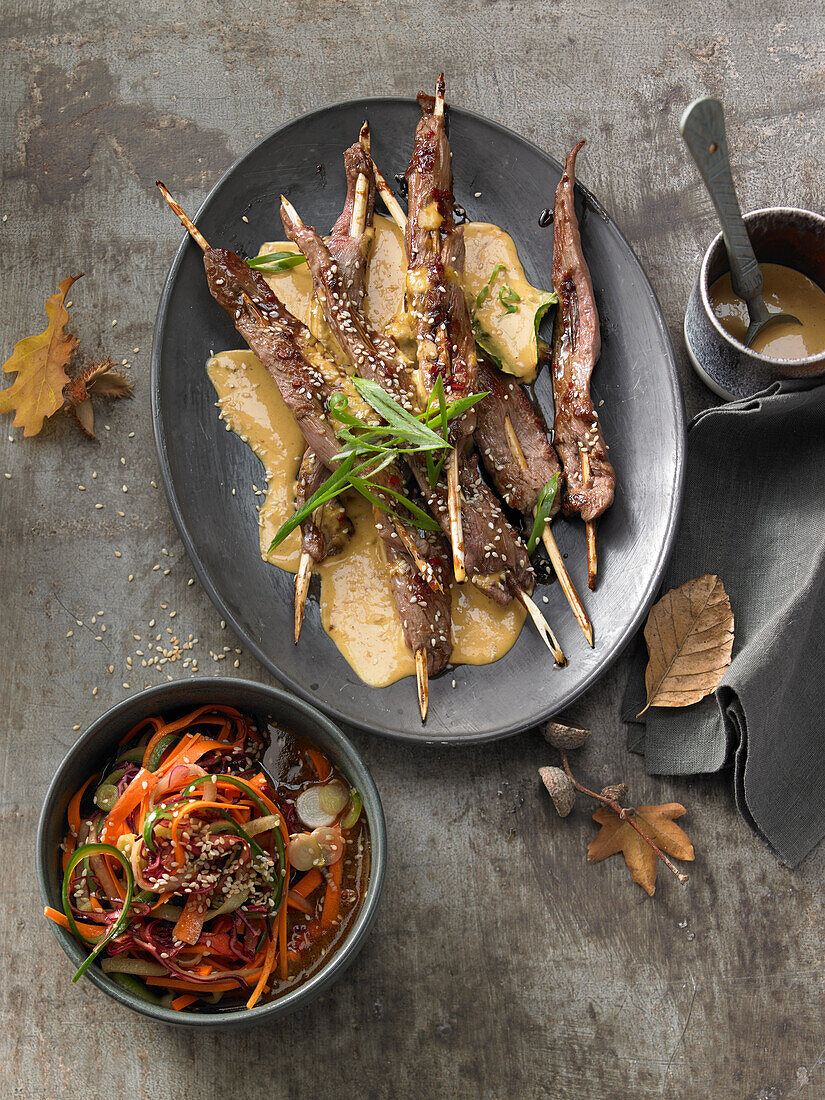 Lamb fillet skewers with a saté sauce and a vegetable salad