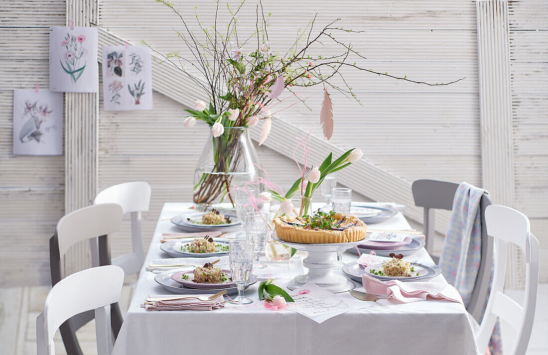 A bouquet of flowers on a spring table laid with appetizers