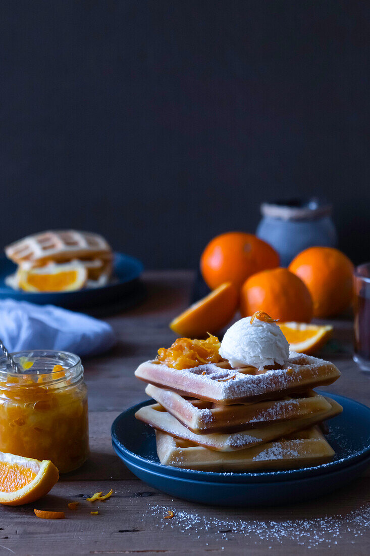 Orange syrup waffles served with vanilla ice cream and orange marmalade