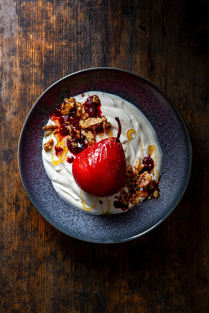 Poached pears with berries and walnut, sesame seeds, and caramel