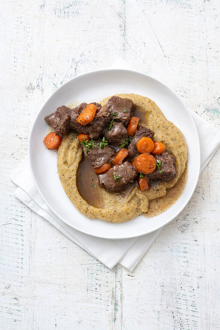 Rindfleischeintopf mit Bier auf Polenta