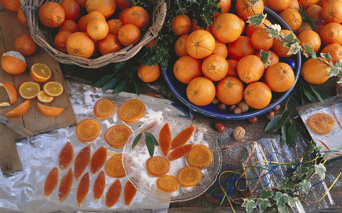 Candied and fresh oranges in bowls on table