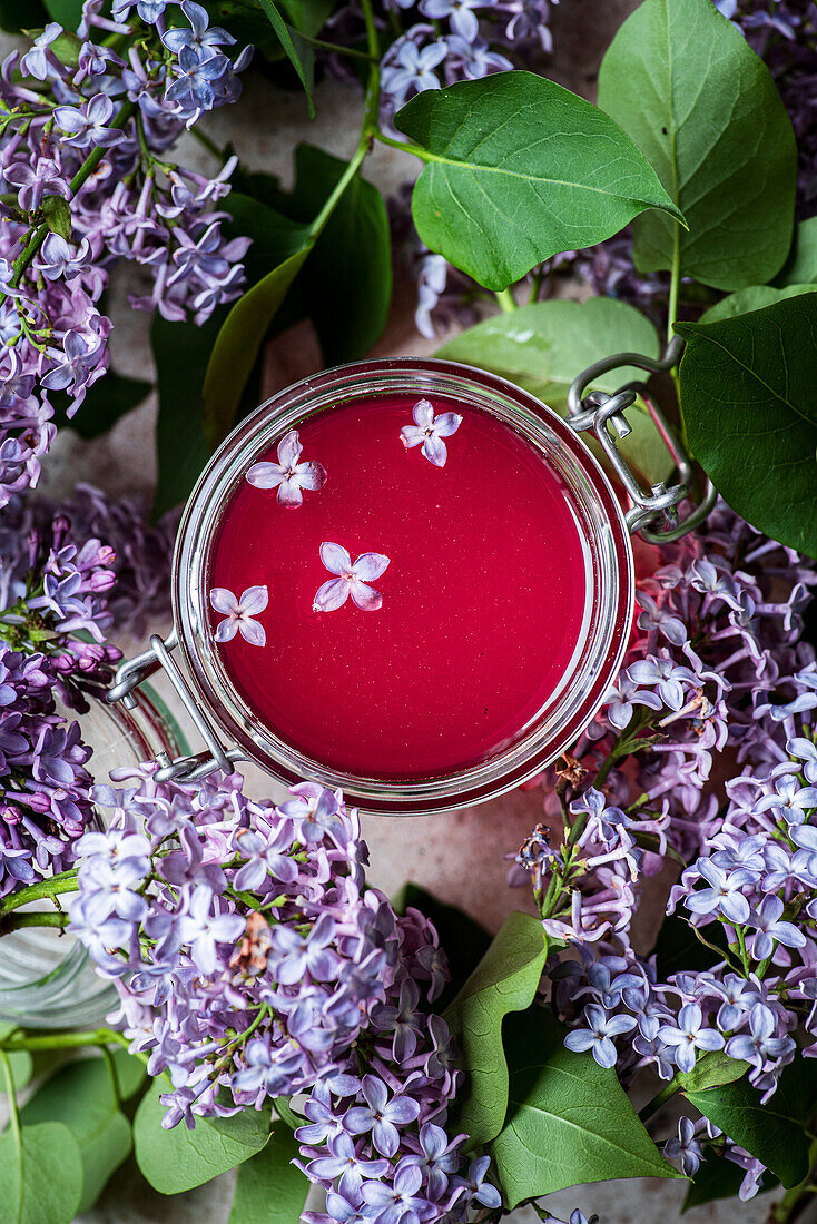 Lilac Syrup in a jar next to lilac blossom