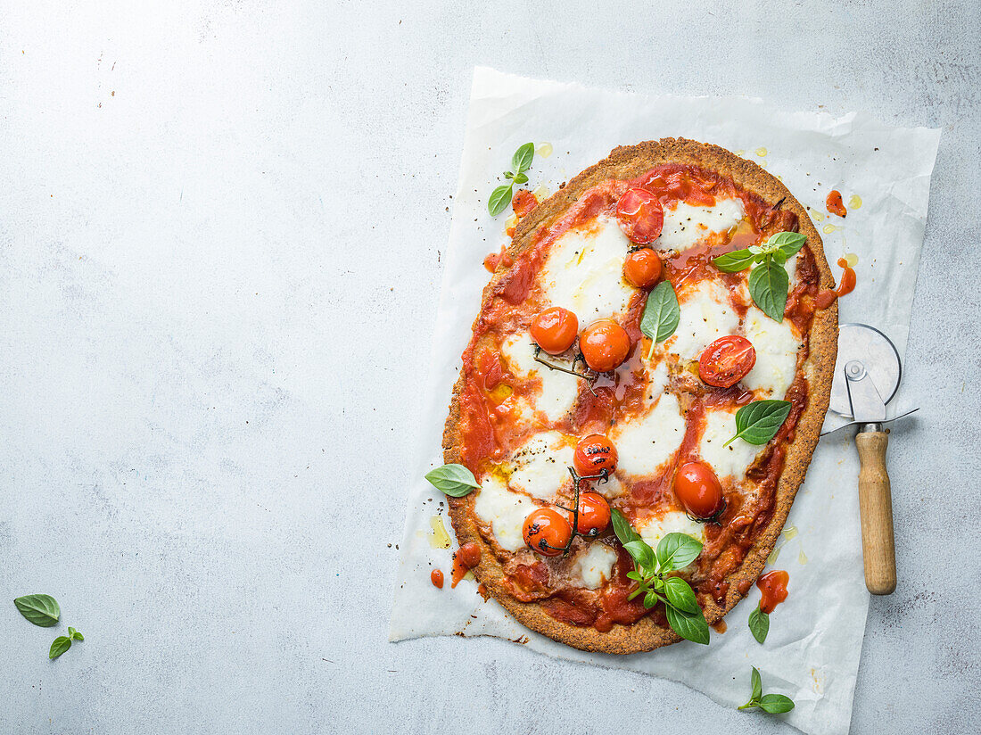 Pizza mit Tomaten, Mozzarella und Basilikum