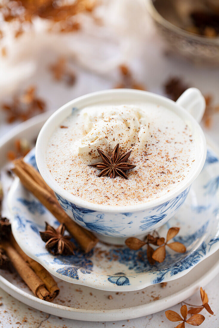 A white hot chocolate flavoured with chai masala and topped with whipped cream and ground spices