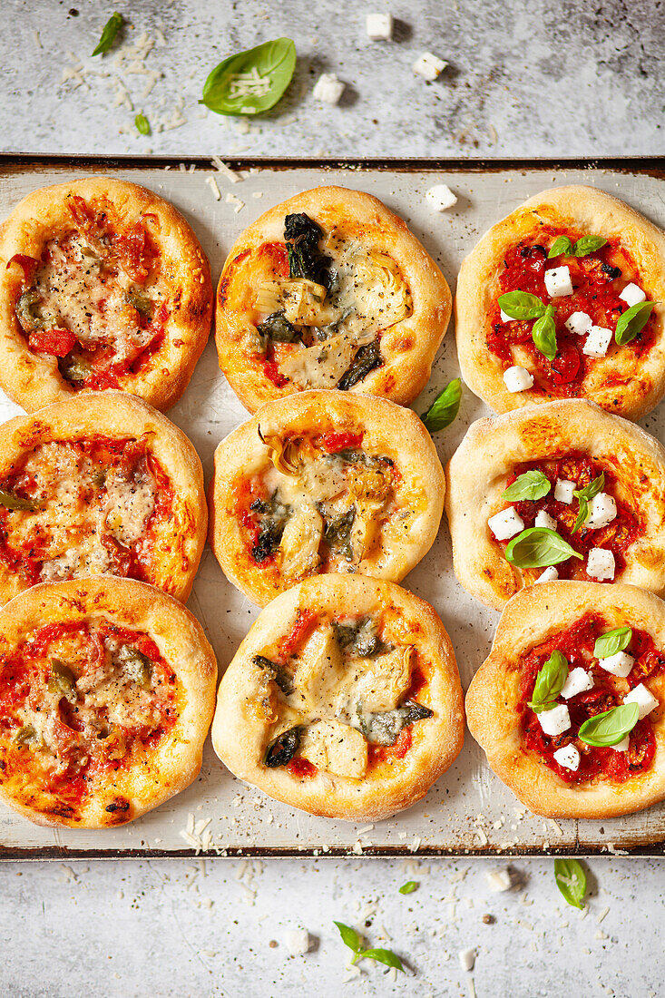 Pizzette (Minipizzen) mit Käse, Tomaten, italienischem Schinken und Chili