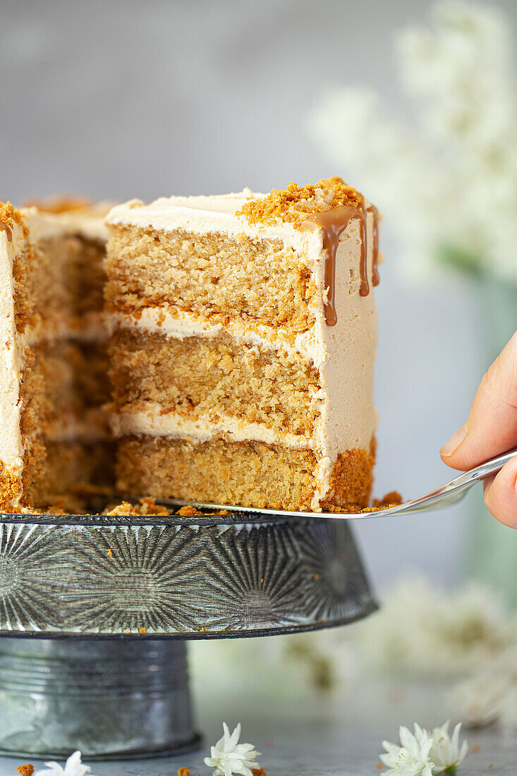 A slice of vegan cookie butter layer cake being sliced ans served