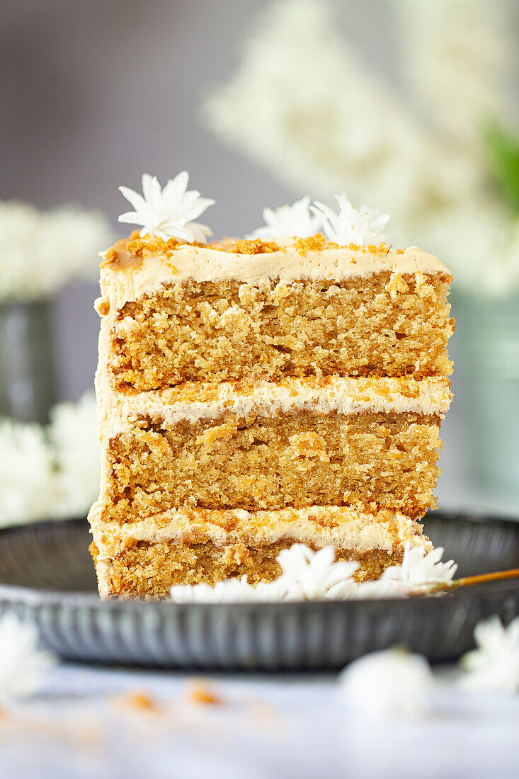 Ein Stück Dripping Cake mit veganer Cookie-Buttercreme und Keksbröseln