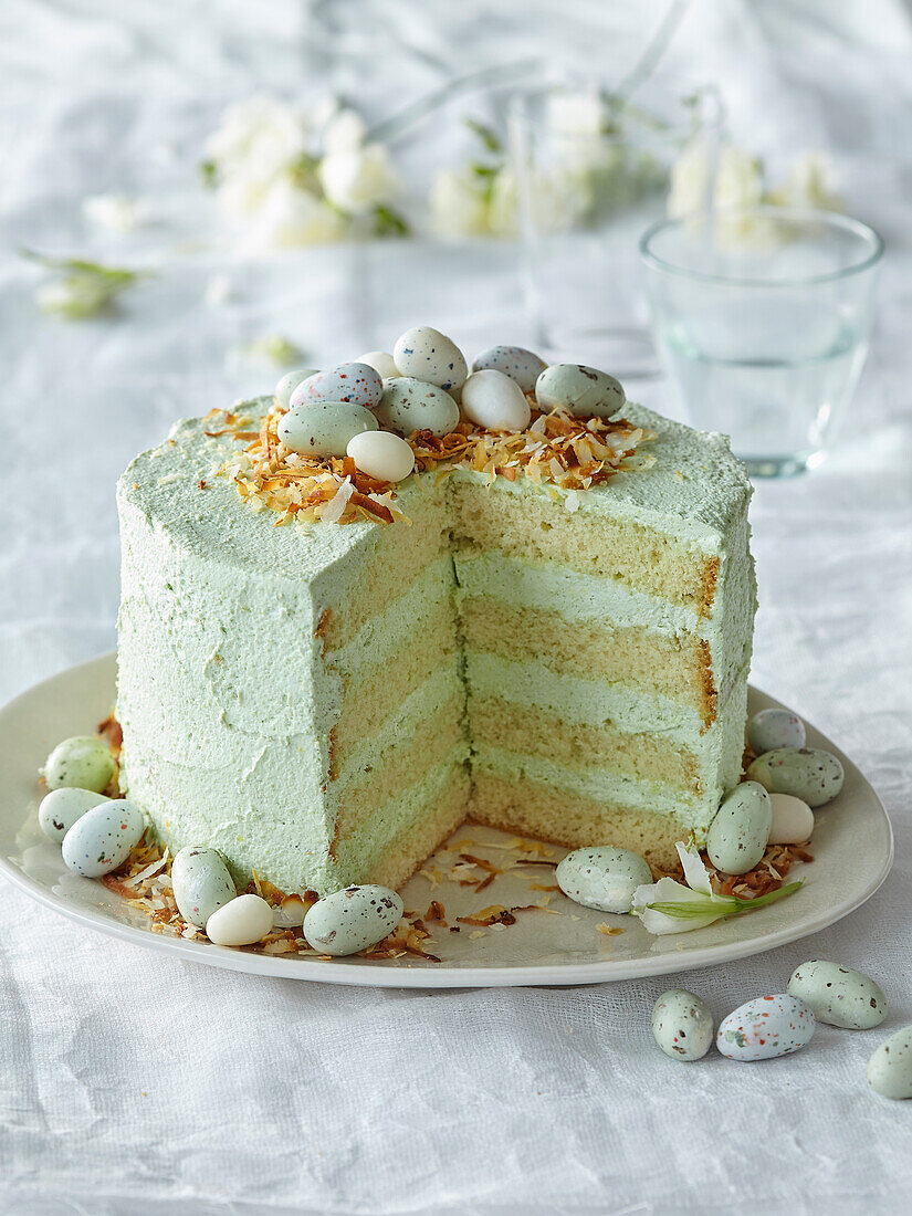 Easter cake with pastel green coconut cream decorated with sugar eggs