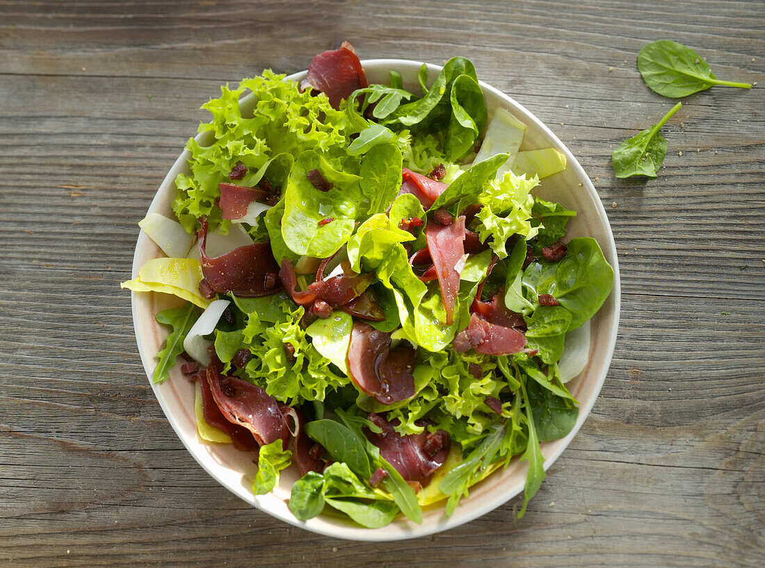 Mesclun with raw ham and pansies