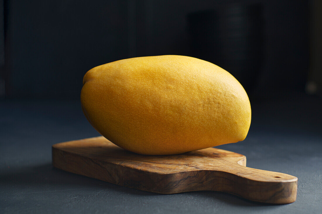 Gelbe Mango auf Holzbrett