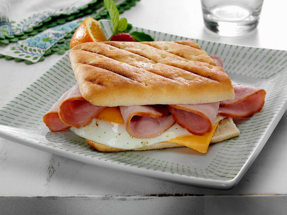 Ham with fried egg and American cheese breakfast panini sandwich