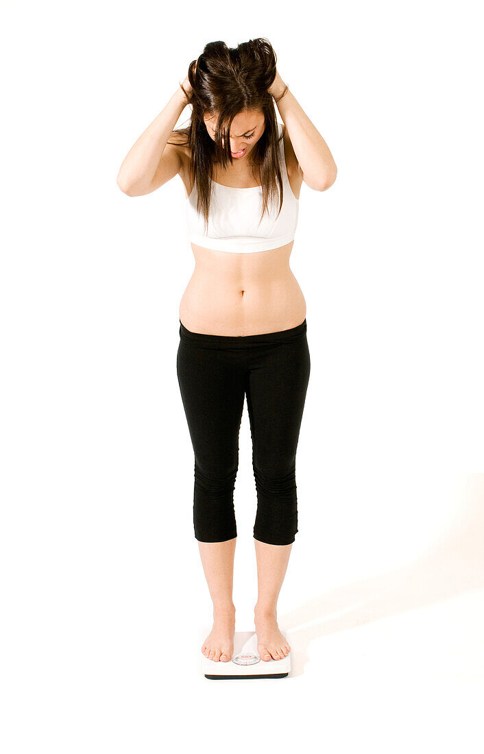 Young woman weighing herself