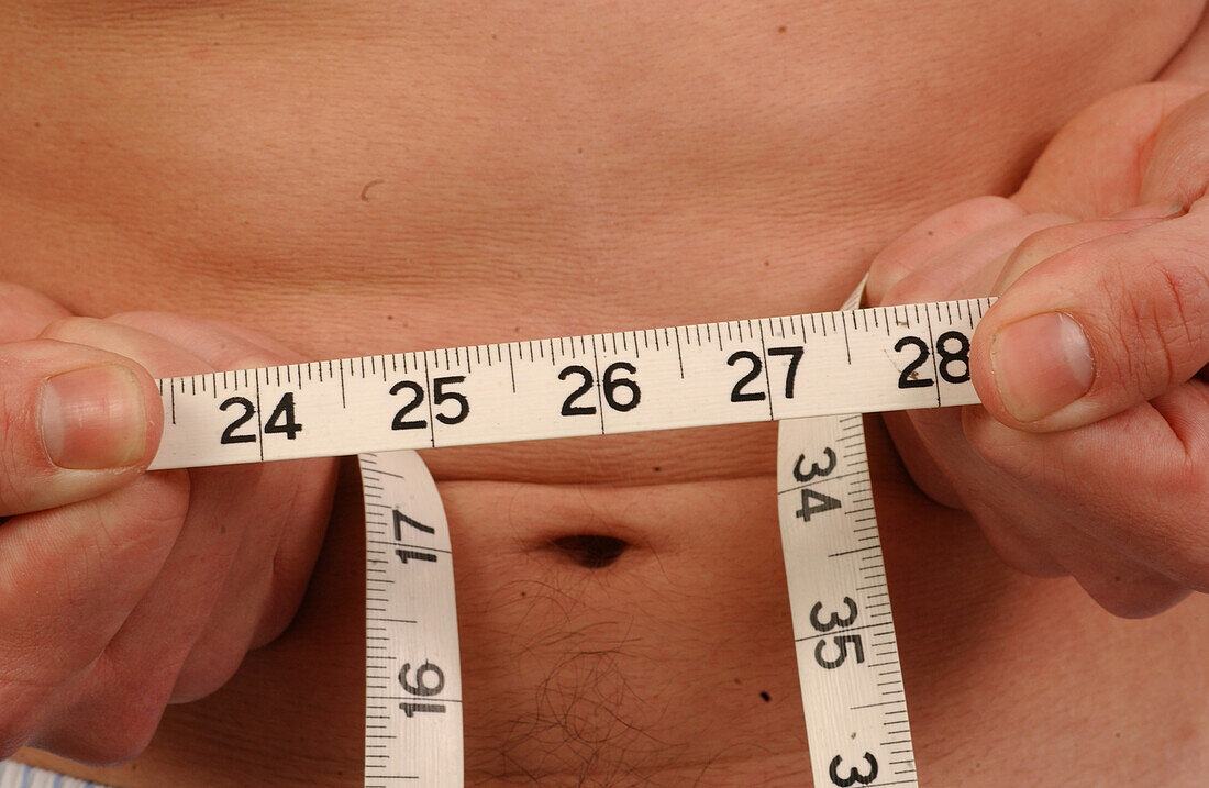 Young man checks his waistline