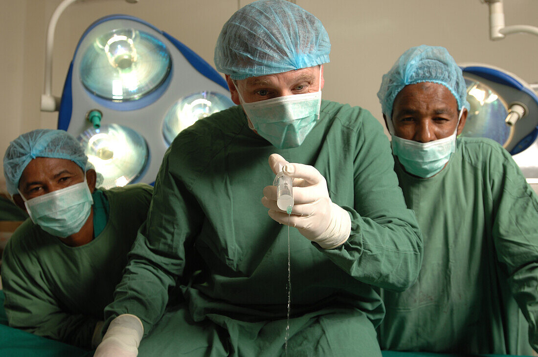 Surgeon sitting next to two assistants