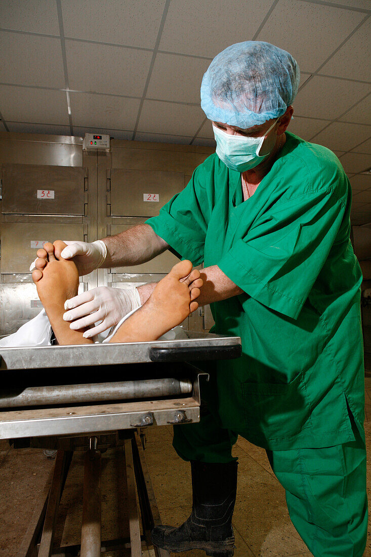 Pathologist examines a cadaver in a mortuary