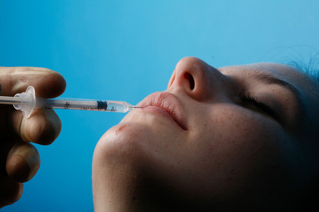 Young woman receiving botox treatment to her lips
