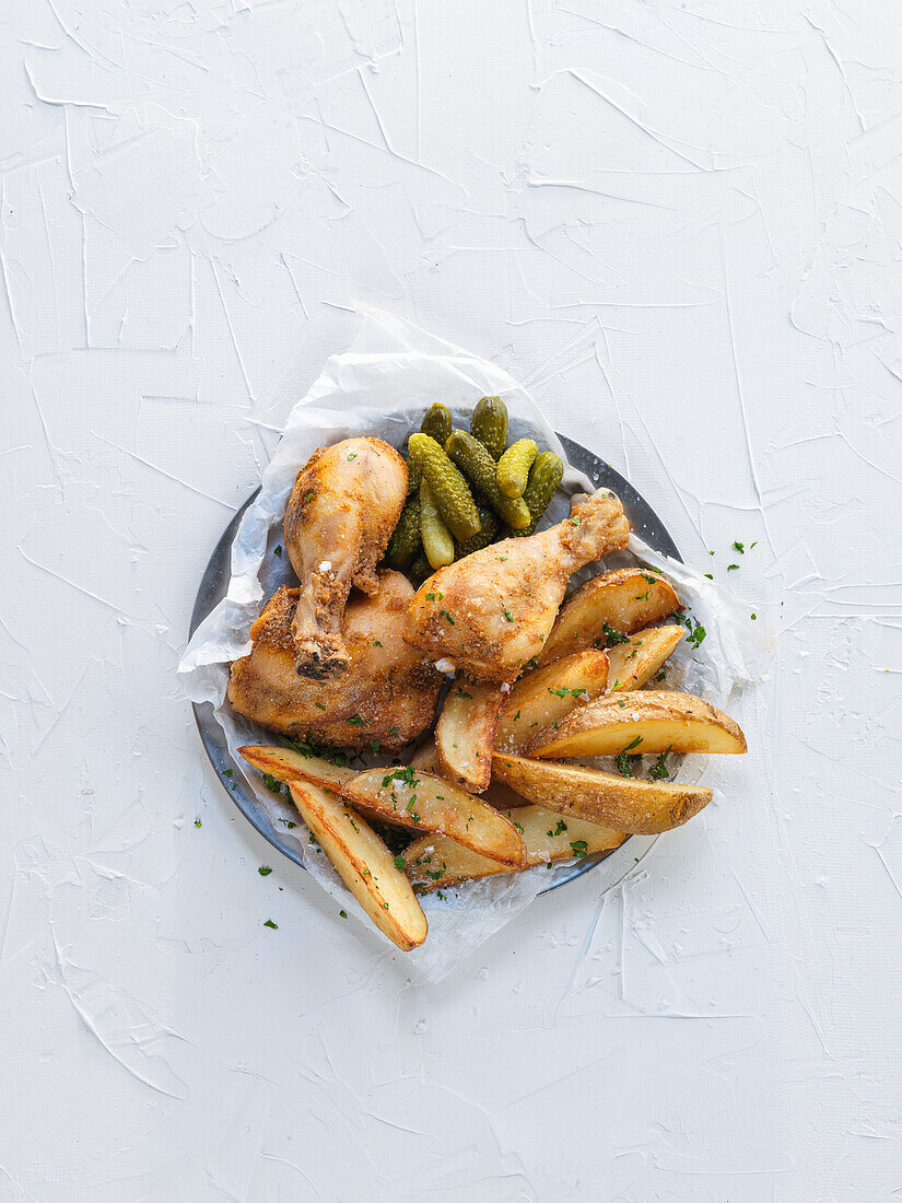 Roast chicken with potato wedges and cornichons