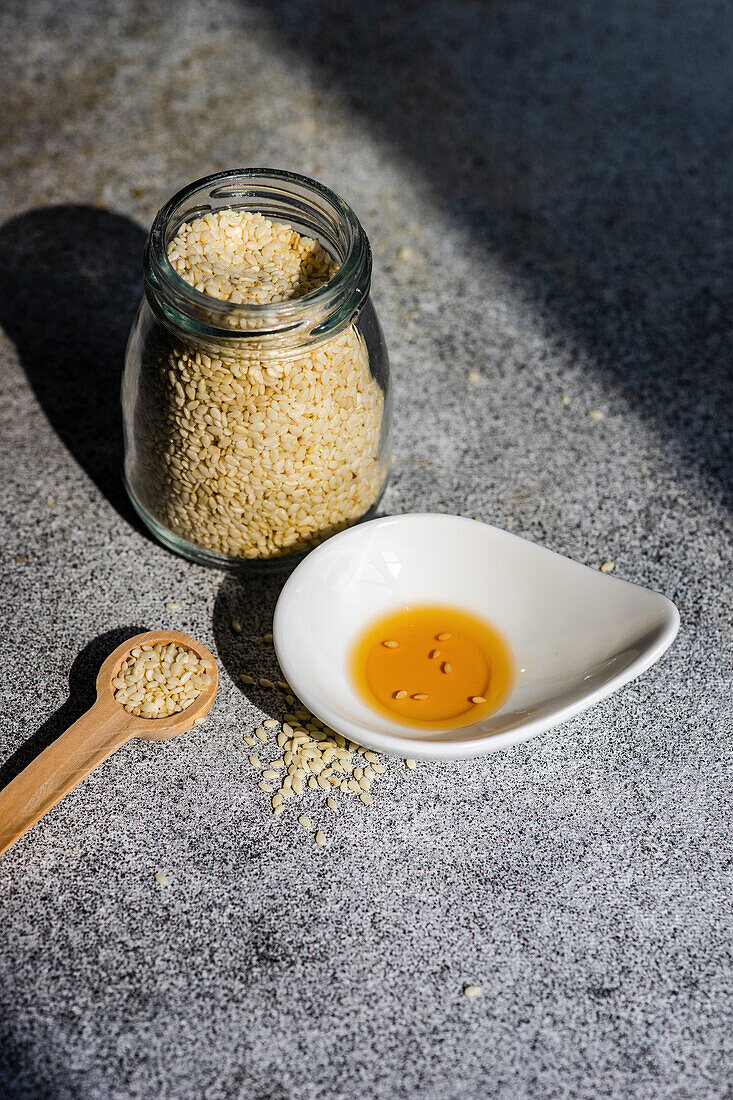 Healthy food concept with sesame seeds in glass jar and oil