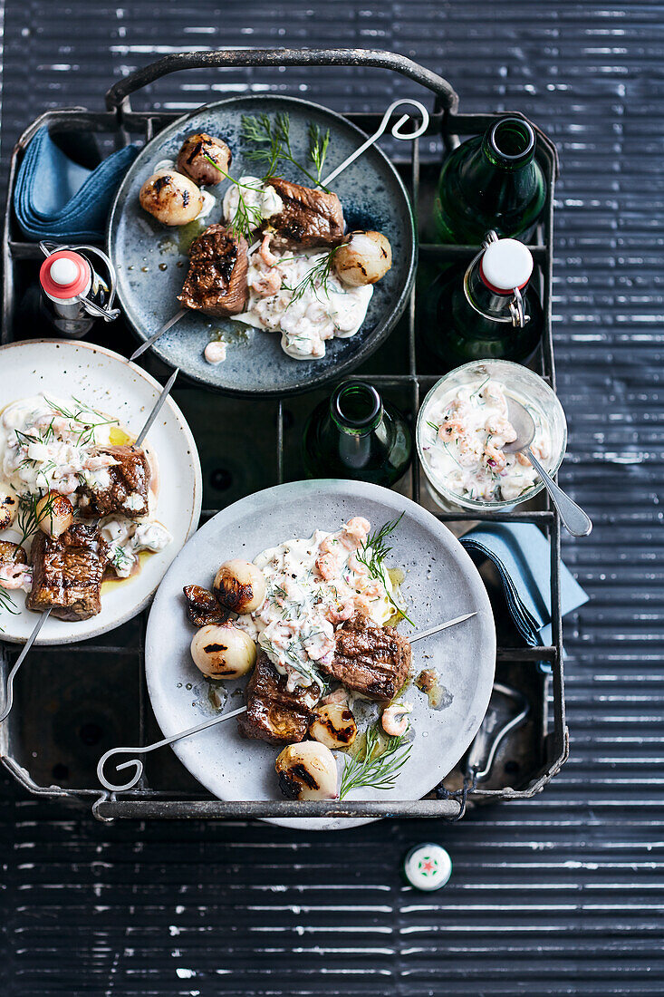 Grilled beef steak skewers with little onions and crab cocktail