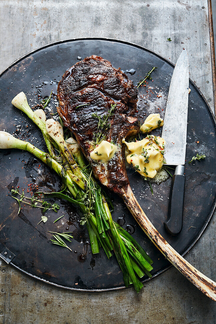 Grilled tomahawk steak with spring onions and chilli herb butter