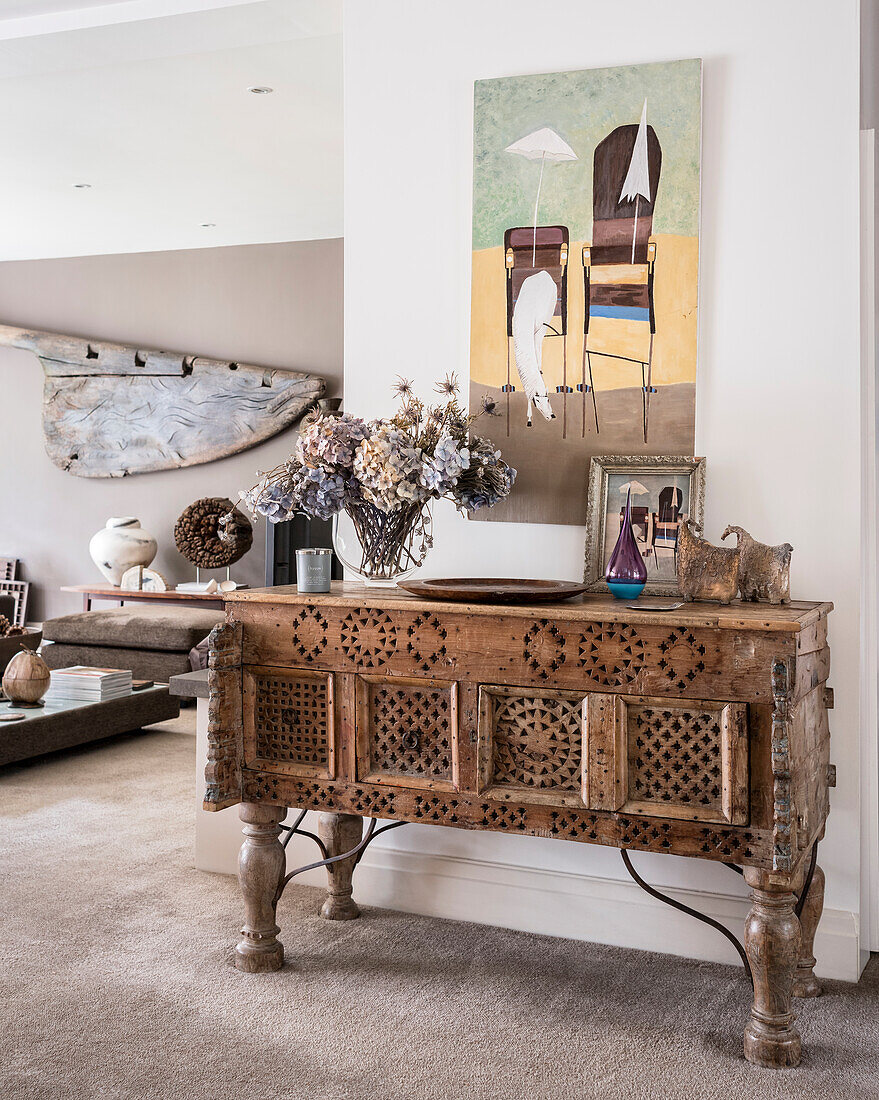 A console table made from old Omani doors in an open-plan living area with an old rudder hung on the wall