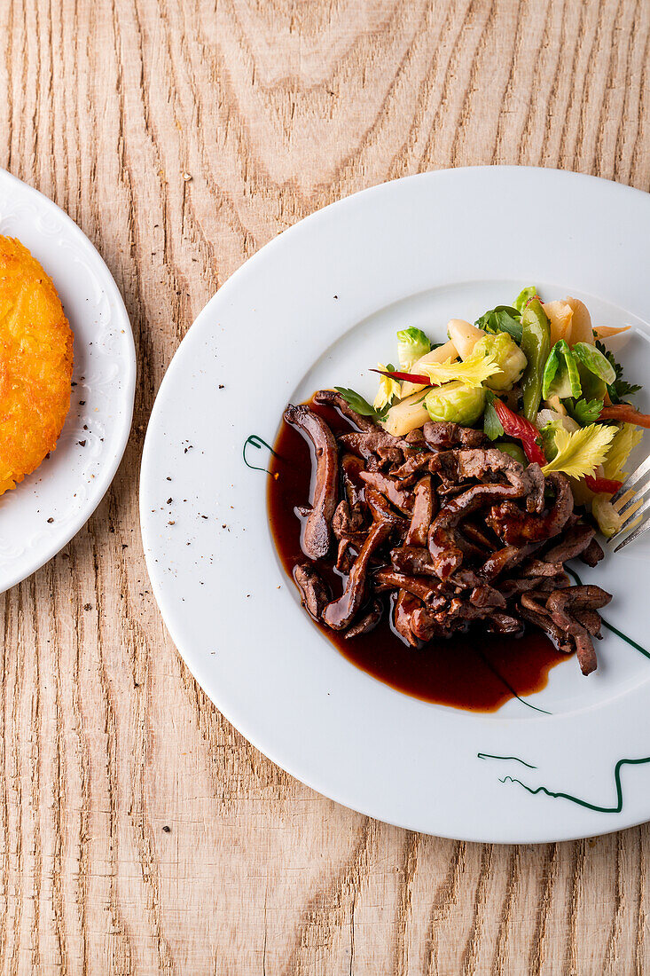 Marinated sliced deer liver with buttered vegetables and fried potatoes