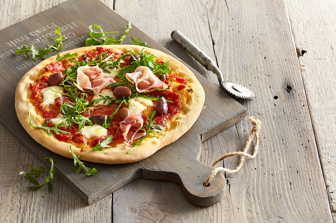 Hausgemachte Pizza mit Schinken und Rucola