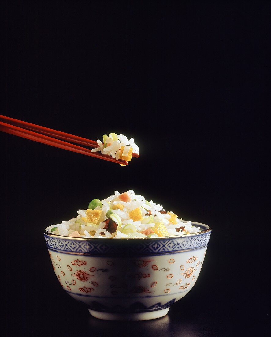 Chinese rice bowl, rice on chopsticks and in bowl