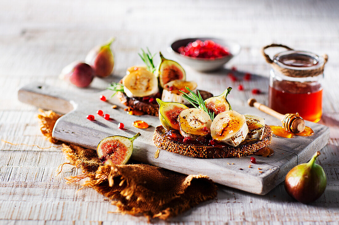 Three-grain bread with goat's cheese, honey, figs and pomegranate seeds