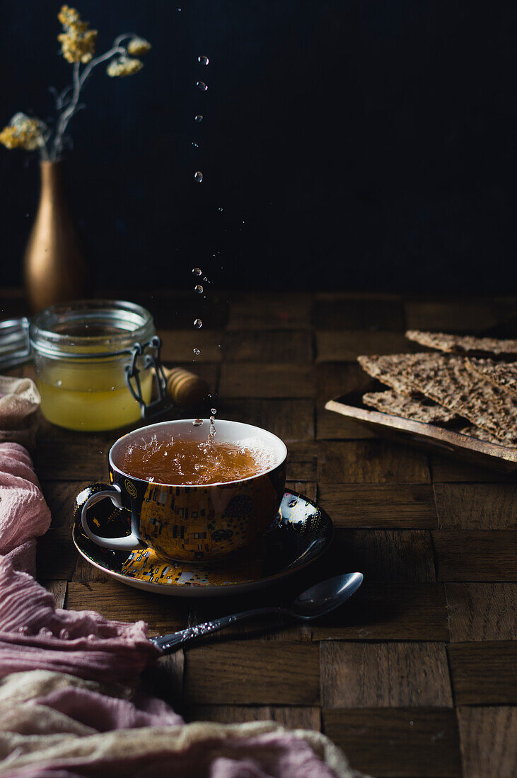 Pouring hot ginger tea into a cup