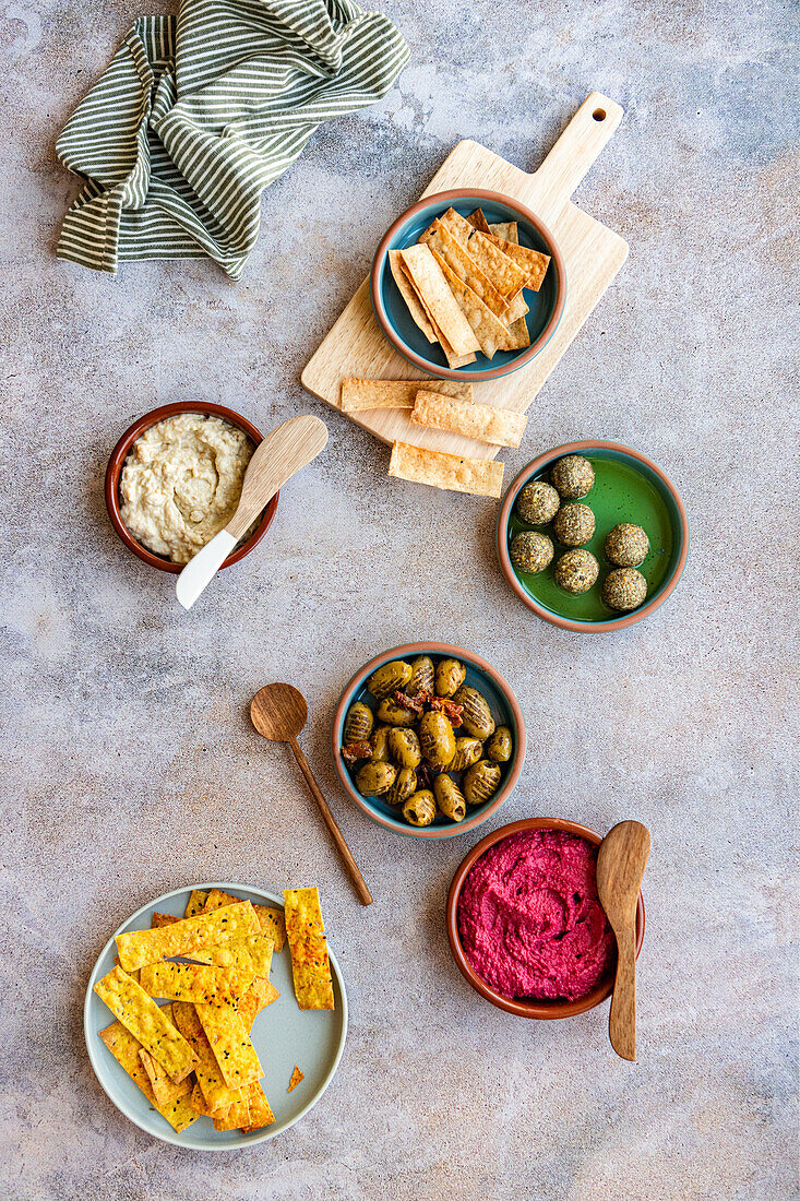 Aufstrich Meze aus hausgemachten Crackern, gegrillten Oliven, Labneh-Bällchen, Rote-Bete-Hummus und Moutabel
