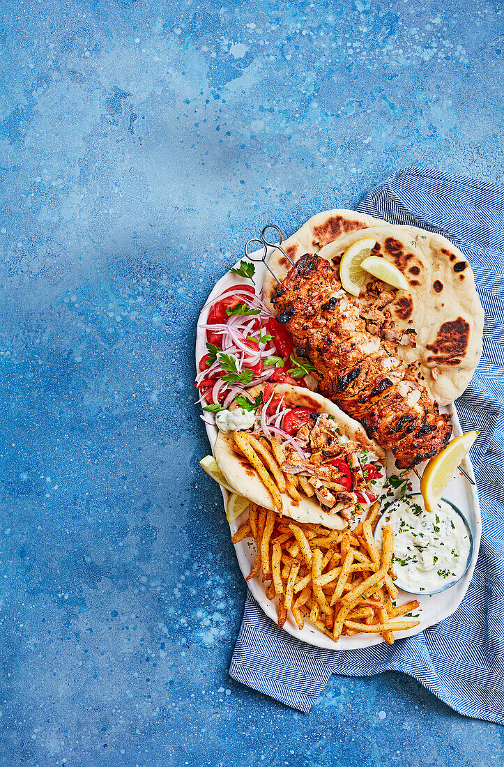Big barbecue chicken kebab with chips, tzatziki and fluffy pittas