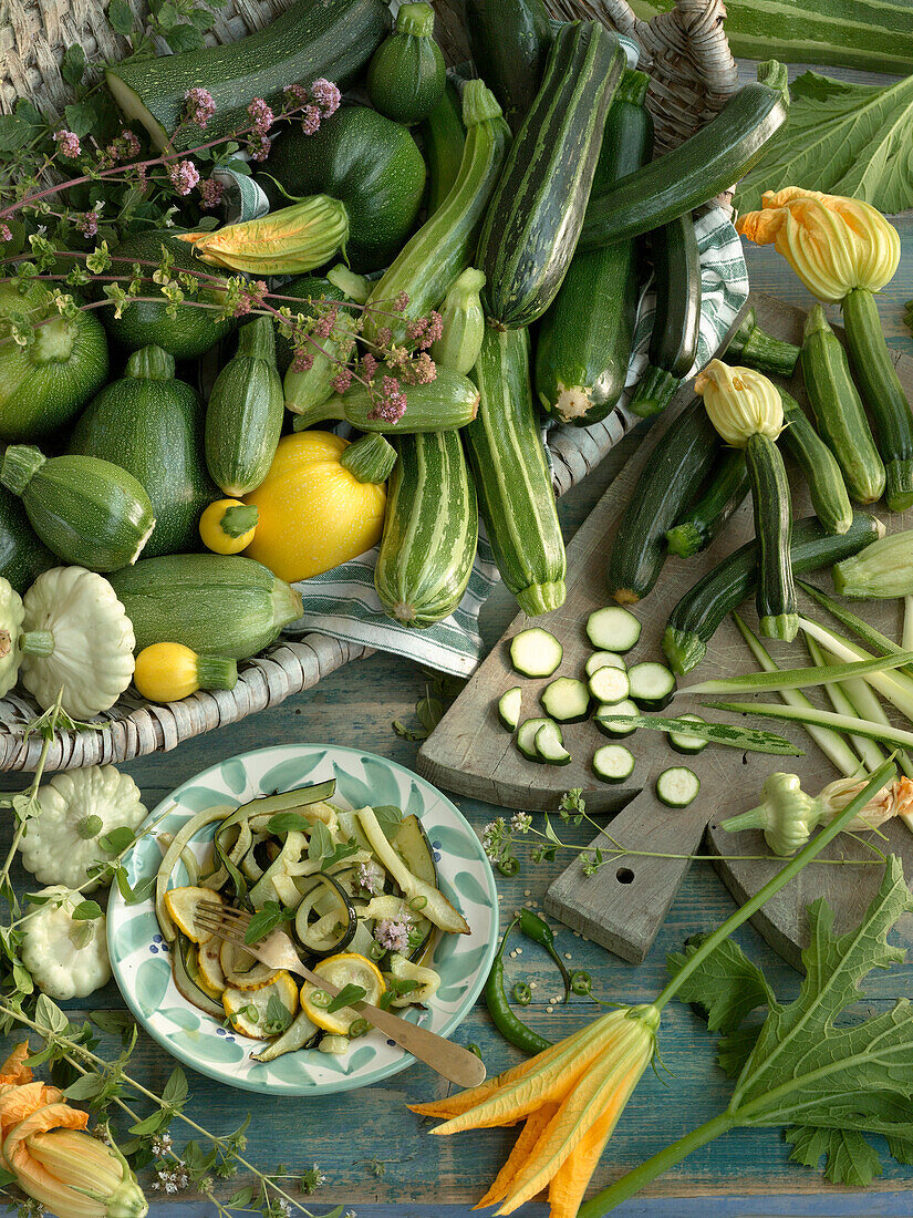Different kinds of courgettes and a plate with baked courgette slices