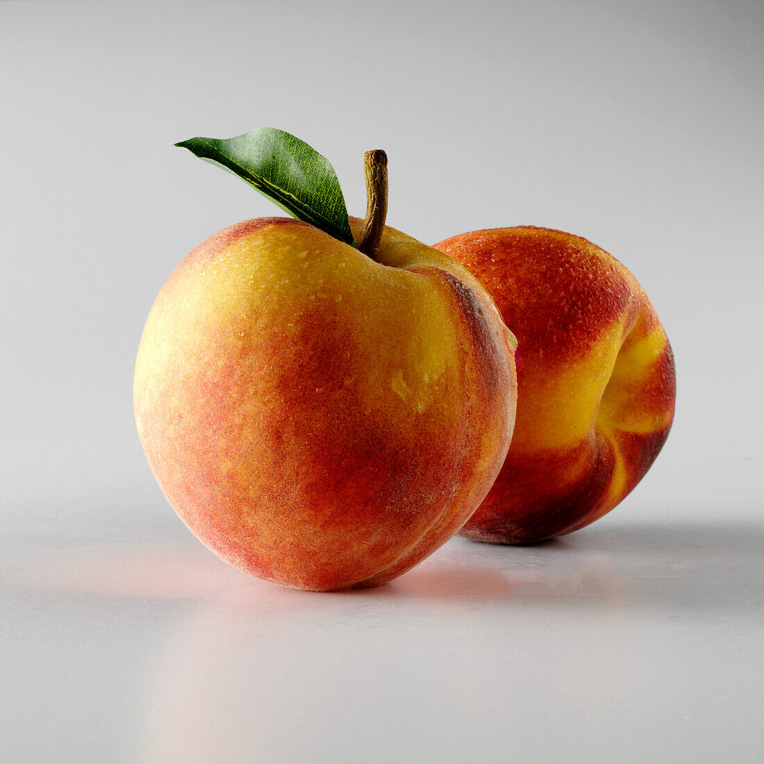 Two peaches on a white background