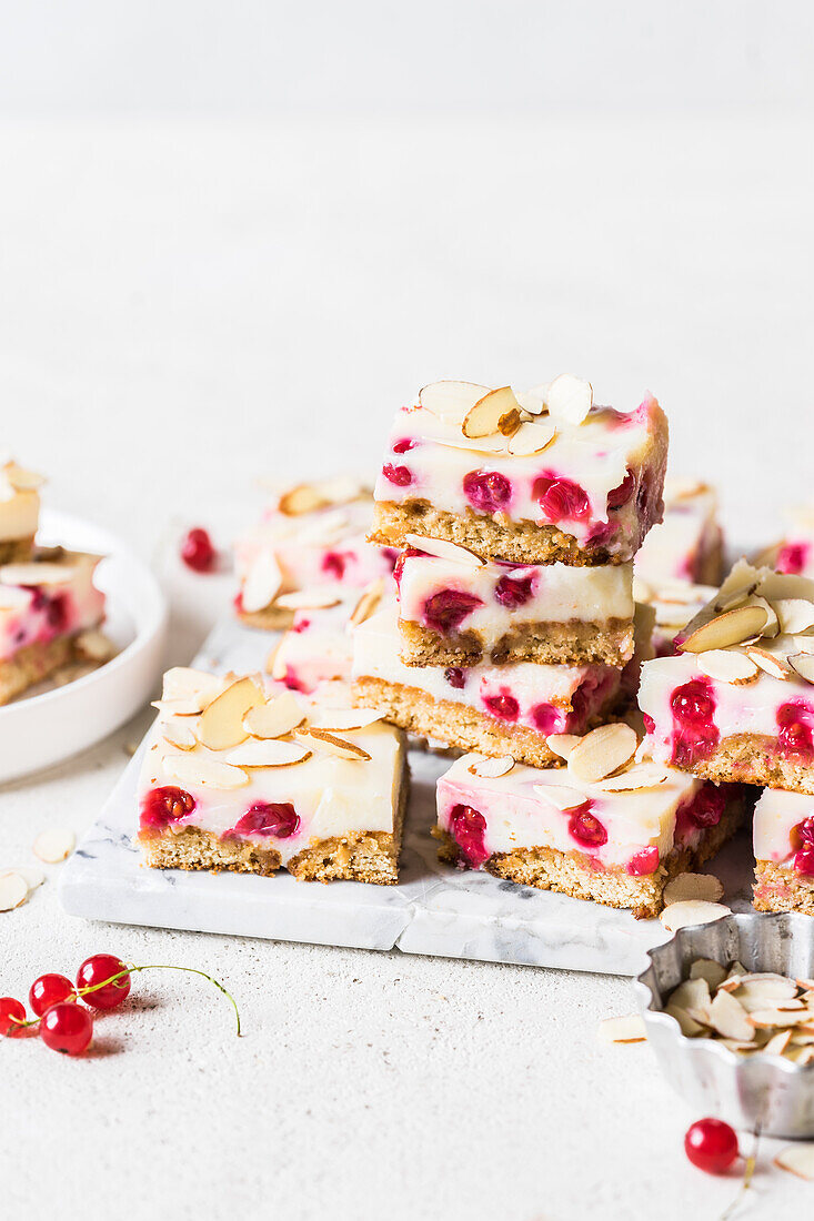 Sweetened condensed milk and degestive cookie slice with fresh redcurrants and almond flakes