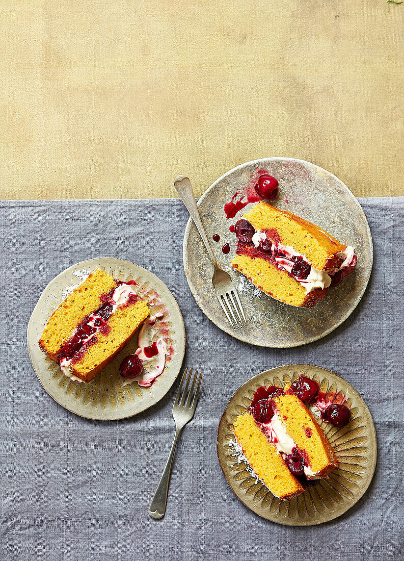 Biskuitkuchenstücke mit Kirschen, Vanillecreme und Mandeln