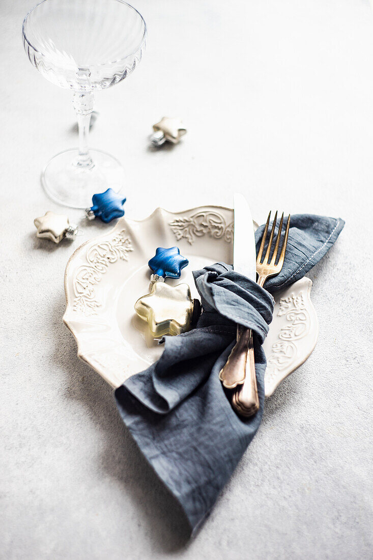 Minimalistic table setting for Christmas dinner on white concrete table