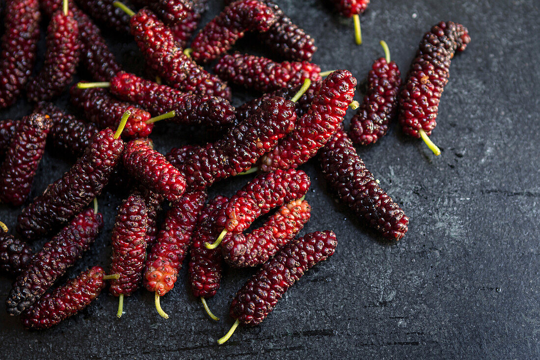 Frische reife Maulbeeren auf dunklem Hintergrund