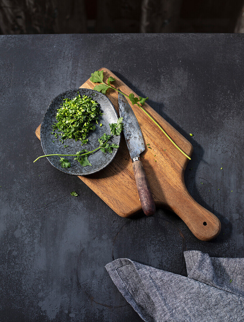 Coriander, Finely chopped on a chopping board in a slate kitchen setting