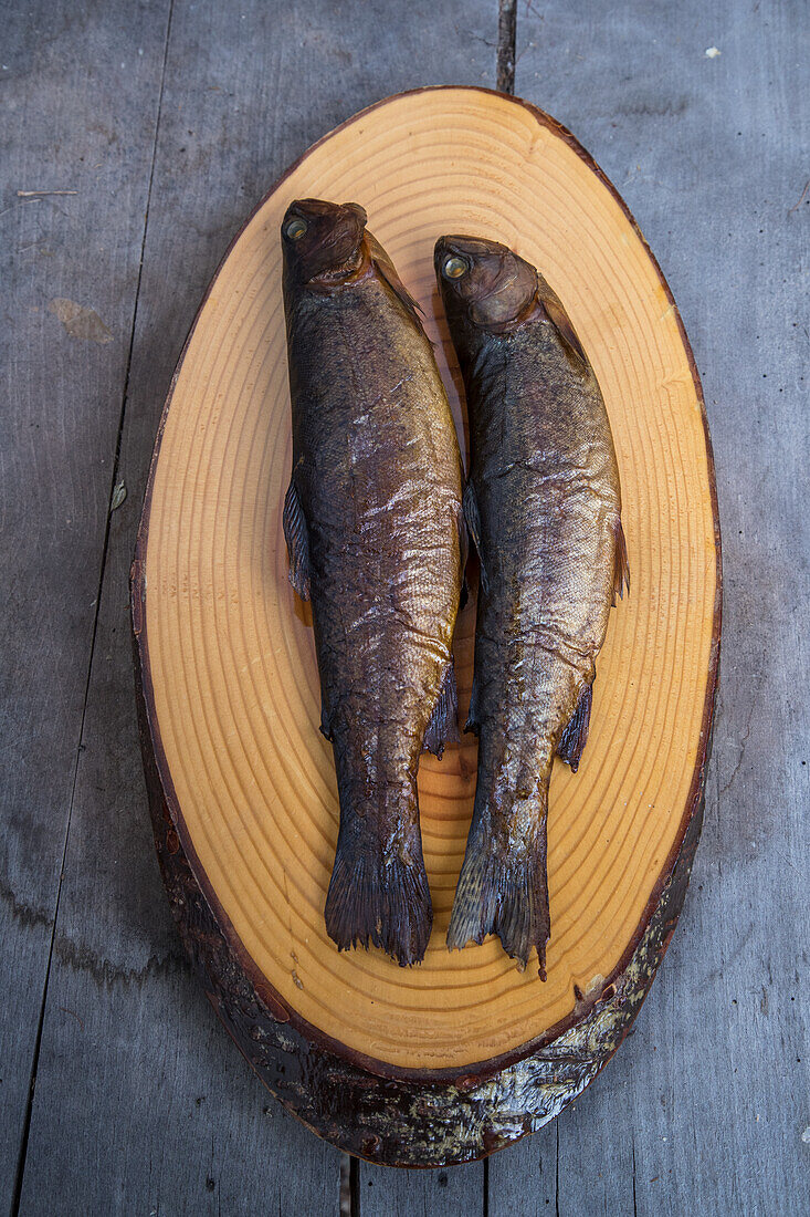 Smoked trout on a tree slice