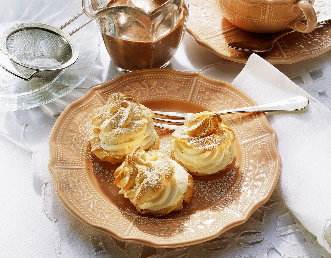 Drei kleine Windbeutel (Profiteroles) mit Vanillecreme