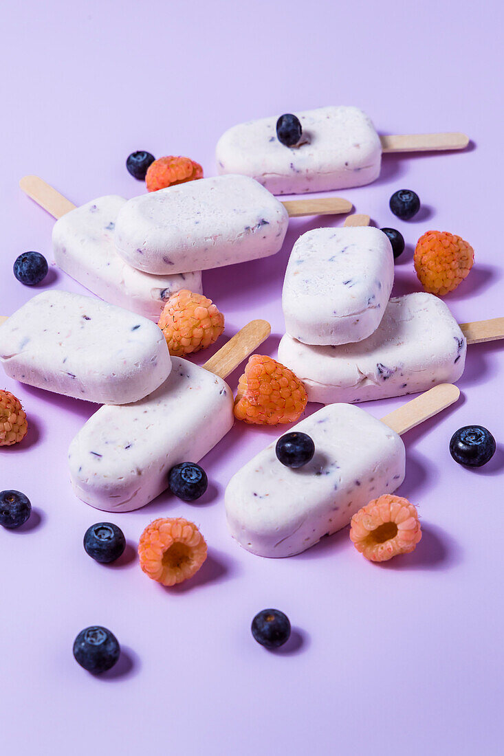 Selbstgemachtes Heidelbeer-Käsekuchen-Eis am Stiel mit Himbeeren