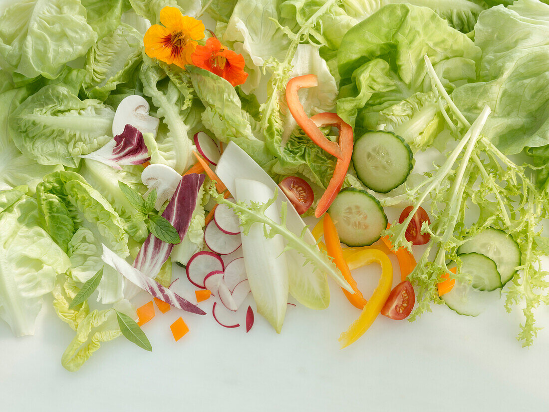 Hellgrüner Salat und verschiedene andere Salatzutaten