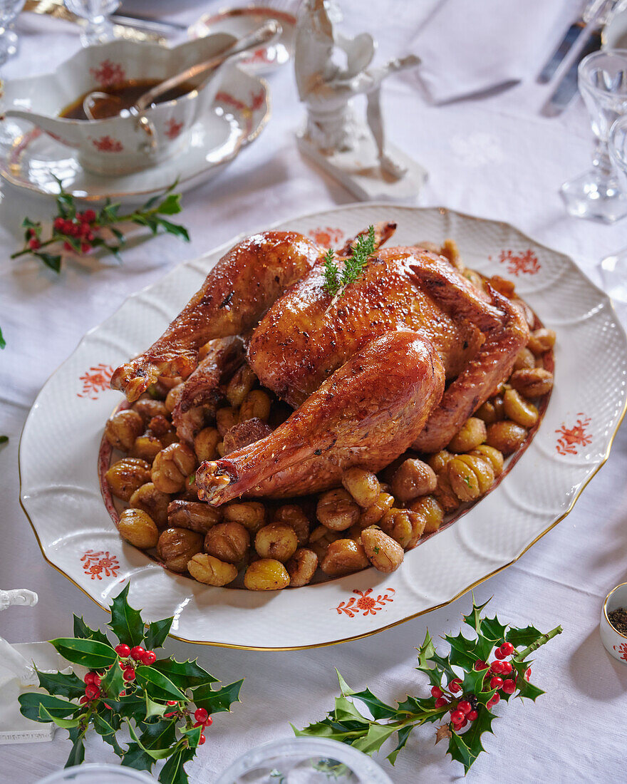 Roasted chicken with chestnuts on a festively decorated table