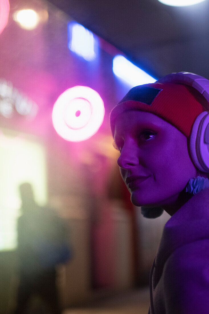 Woman with headphones in neon light