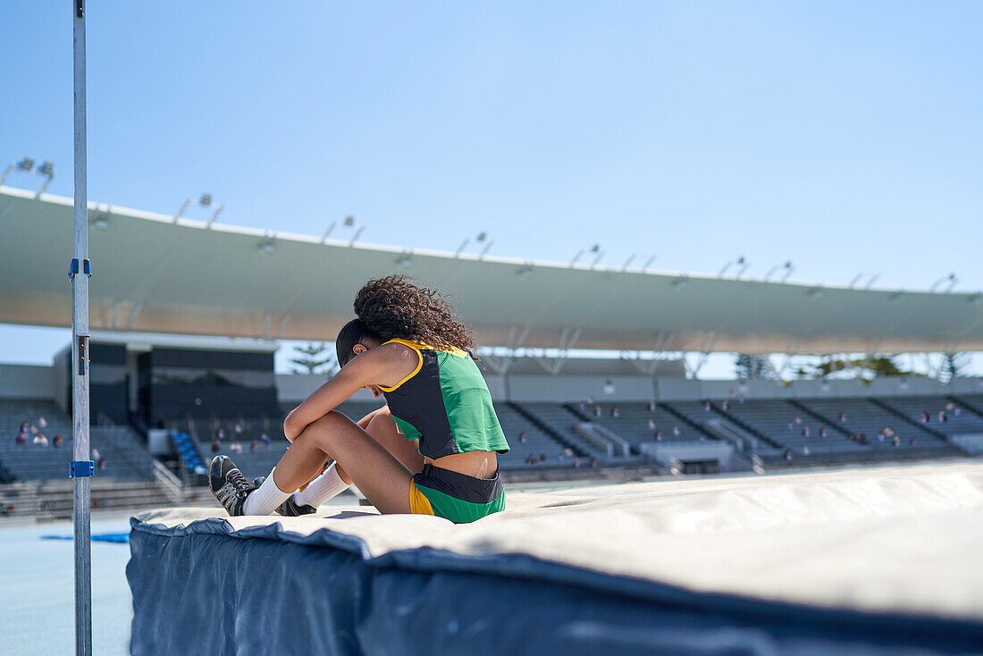 Female high jumper in sunny stadium