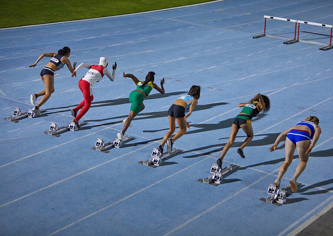 Female track and field athletes at starting blocks